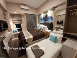 a hotel room with two beds and a bathroom at The Paneya @Tanglin Apartment in Surabaya