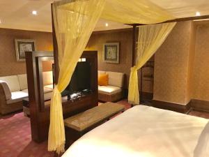 1 dormitorio con cama, sofá y TV en Kai Wei Boutique Hotel en Taipéi