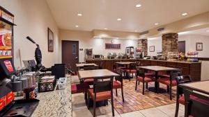 a restaurant with tables and chairs in a room at SureStay Plus Hotel by Best Western Coffeyville in Coffeyville