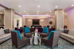 a lobby with couches and chairs and a flat screen tv at La Quinta by Wyndham Gainesville in Gainesville