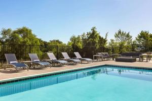 a pool with chaise lounge chairs and a row ofvationvation at La Quinta Inn & Suites by Wyndham College Station North in College Station
