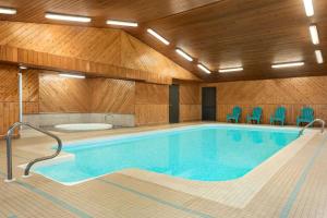 a large swimming pool with blue chairs in a building at Travelodge by Wyndham Port Elgin in Port Elgin