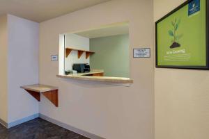 
a bathroom with a mirror and a sink at WoodSpring Suites Washington DC Andrews AFB in Camp Springs
