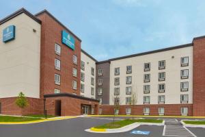 a rendering of a hotel with a parking lot at WoodSpring Suites Washington DC Northeast Greenbelt in Greenbelt