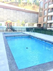 a large blue swimming pool in front of a building at Parque Mirador II - 3 Dormitorios - Excelente vista in Viña del Mar