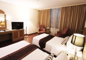 a hotel room with two beds and a television at Grand Tower Inn Rama 6 - SHA Extra Plus in Bangkok