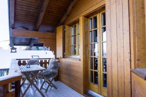 a wooden cabin with a table and chairs on a patio at Chalet le Joyau in Nendaz - Sleeps 6 - Panoramic Views - 4 Vallées in Nendaz