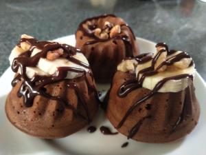 three chocolate covered donuts on a white plate at Spring Villa in Nanzhuang