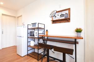 a kitchen with a counter and a table and a refrigerator at E-horizon Resort コンドミニアム名護 A in Nago