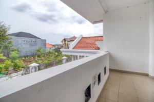 un balcon avec vue sur un immeuble dans l'établissement RedDoorz Hostel near Stadion Mandala Krida Yogya, à Yogyakarta