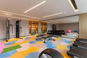 a fitness room with a gym with desks and chairs at Hyatt Place Changchun Jingyue in Changchun