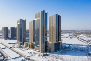 長春市にあるHyatt Place Changchun Jingyueの雪の高い建物群