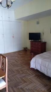 a bedroom with a bed and a flat screen tv at carmon colon 1 ambiente y medio in Mar del Plata