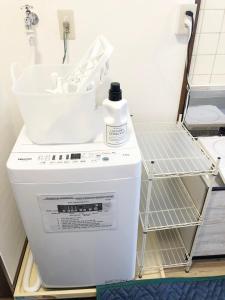 a washing machine with a bottle of detergent on top of it at ラ・ポート空港前201 in Fukuoka
