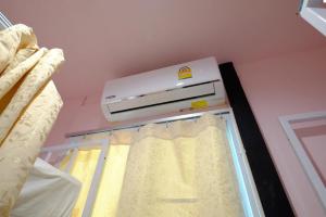um quarto com uma cama com uma janela e ar condicionado em Sangchan hostel em Ko Lipe