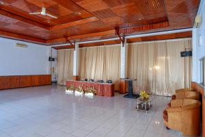 a large room with a table and chairs and a stage at RedDoorz @ Hotel Horas Palopo in Palopo