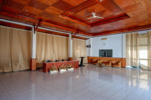 a large room with wooden ceilings and a table with chairs at RedDoorz @ Hotel Horas Palopo in Palopo