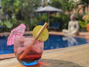 a drink sitting on a table next to a pool at Raingsey Bungalow in Kep