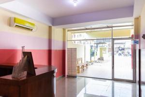 een kamer met kleurrijke muren, een bureau en een raam bij RedDoorz Plus @ Jalan Gatot Subroto Medan in Sunggal
