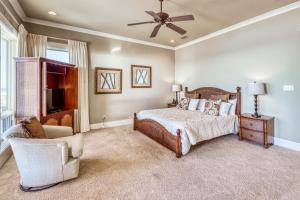 1 dormitorio con 1 cama, 1 silla y ventilador de techo en Casa Del Mar, en Gulf Shores