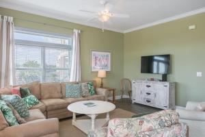 sala de estar con sofá y TV en Serenity, en Gulf Shores