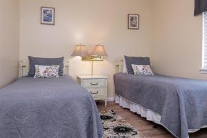 a bedroom with two beds and a table with a lamp at Gulf Village #215 in Gulf Shores