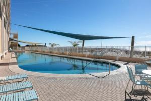 a large swimming pool with chairs and a table at San Carlos #1808 in Gulf Shores