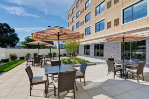 un patio con mesas, sillas y sombrillas en Holiday Inn Express Boston, an IHG Hotel en Boston