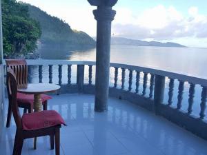 a table and chair on a balcony overlooking the water at Leyte Seaview Stay in Himay-añgan