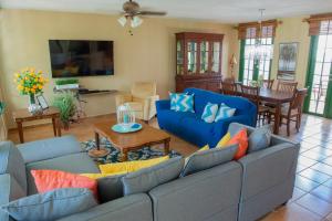 a living room with blue couches and a table at Villa Coral Reef- 4BR with community pool overlooking ocean in Dorado