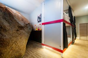 a room with a large rock next to a bed at So Good Haad Rin Hostel in Haad Rin