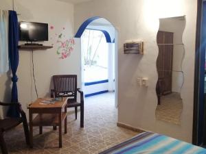 a living room with an archway and a table and a chair at House Jardin Del Caribe in Las Terrenas