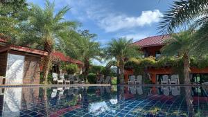 ein Swimmingpool vor einem Haus mit Palmen in der Unterkunft Chomview Resort in Ko Lanta