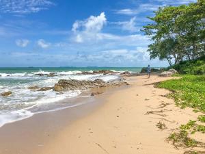 uma pessoa a caminhar numa praia de areia perto do oceano em Chomview Resort em Ko Lanta