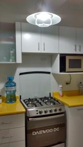 een keuken met een fornuis en een licht bij Apartamento completo en centro historico in Lima