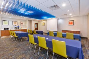 a conference room with blue tables and yellow chairs at Holiday Inn Express Hotel & Suites Cleveland-Richfield by IHG in Brecksville +23 photos