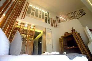 una camera con letto e specchio di Tharaburi Resort a Sukhothai