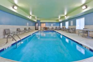 a pool with chairs and tables in a hotel room at Holiday Inn Express Hotel & Suites Cleveland-Richfield by IHG in Brecksville