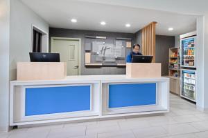 a man standing at a counter with a laptop at Holiday Inn Express Hotel & Suites Watsonville, an IHG Hotel in Watsonville