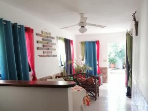 a living room with colorful curtains and a ceiling fan at House Jardin Del Caribe in Las Terrenas