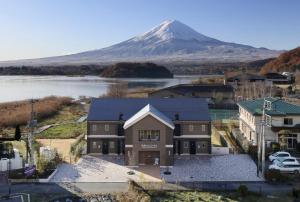 a house with a mountain in the background at Kawaguchiko Urban Resort Villa in Fujikawaguchiko