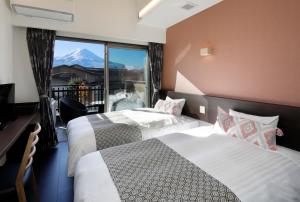 2 letti in una camera con vista sulle montagne di Kawaguchiko Urban Resort Villa a Fujikawaguchiko