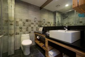 a bathroom with a white toilet and a sink at Hotelday+ Kenting in Kenting