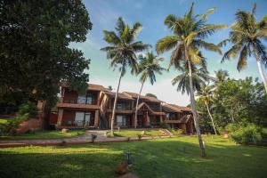 an exterior view of a resort with palm trees at AMARA AYURVEDA RETREAT- Overlooking Evergreen Western Ghats an ecologically sustainable living space in Kovalam in Kovalam