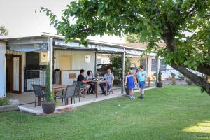 a group of people sitting at a table in a yard at Indigo Vineyard Farmstay in Beechworth +5 photos