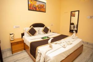 a bedroom with a large bed with towels on it at Hotel Dimple International in Udaipur