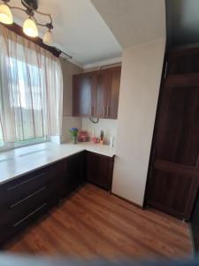 una cocina vacía con armarios de madera y una ventana en Порт Сіті, en Lutsk