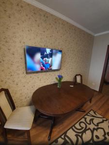 ein Wohnzimmer mit einem Holztisch und einem TV an der Wand in der Unterkunft Порт Сіті in Luzk