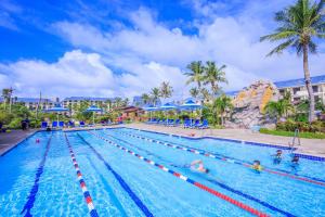 a swimming pool at a resort with people in it at Pacific Islands Club Saipan in Chalan Kanoa