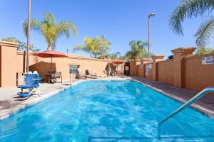 a swimming pool with blue water in a resort at Holiday Inn Express & Suites Corona, an IHG Hotel in Corona